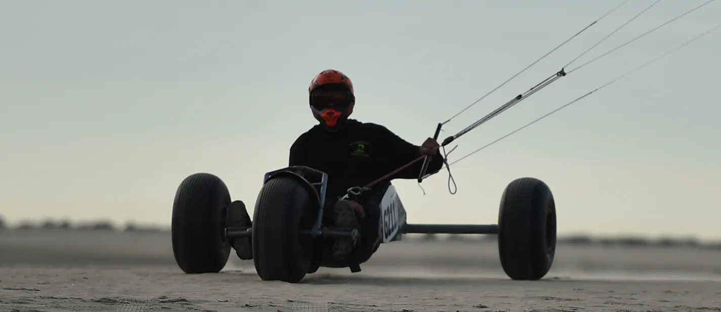 Kitebuggyrijder met rode helm van dichtbij